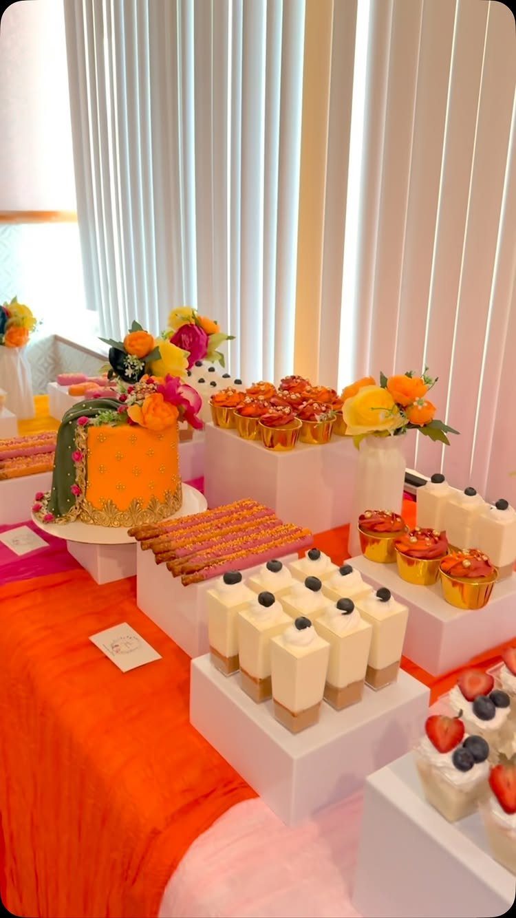 21 Colorful Wedding Table Settings for Every Style and Budget 21 Colorful desserts including an orange cake and white mousse arranged on white stands over an orange tablecloth.