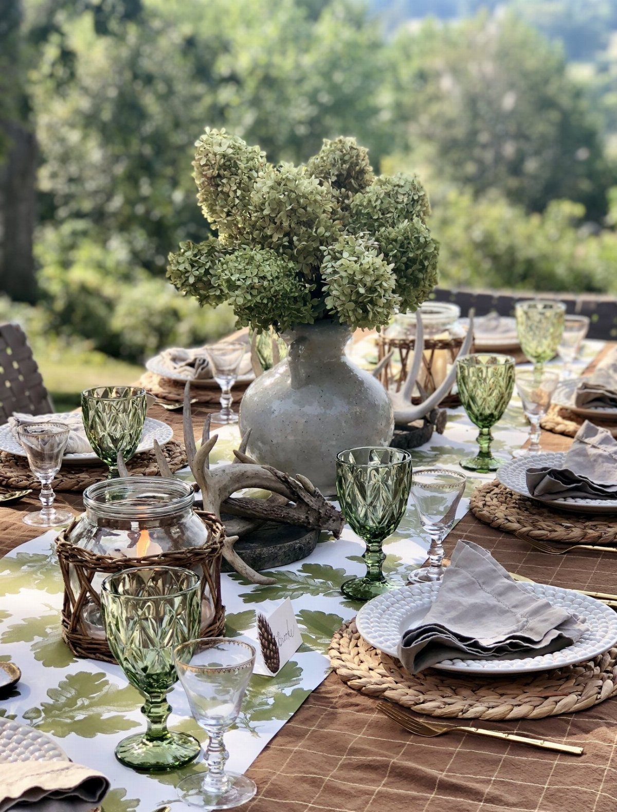 21 Colorful Wedding Table Settings for Every Style and Budget 2 Green patterned glassware and hydrangeas arranged on a decorated outdoor wedding dining table.