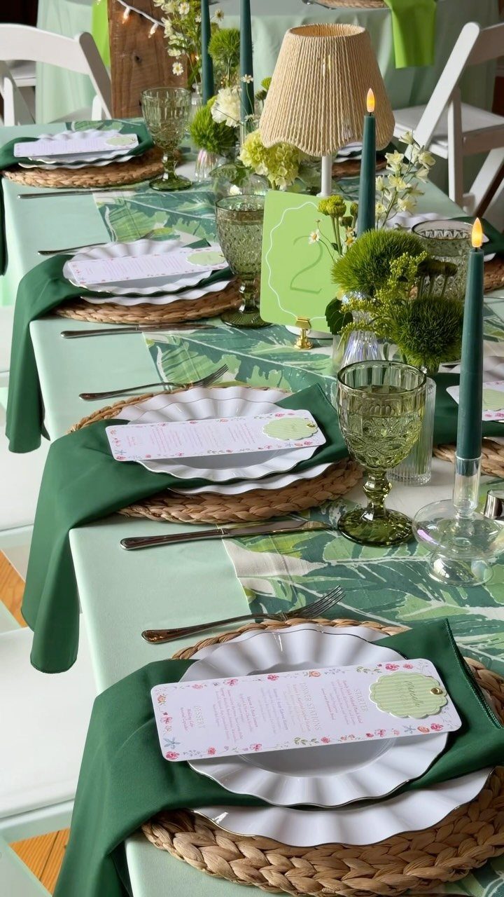 21 Colorful Wedding Table Settings for Every Style and Budget 7 A wedding table set with tropical leaf patterned runners, green napkins, and white scalloped plates.