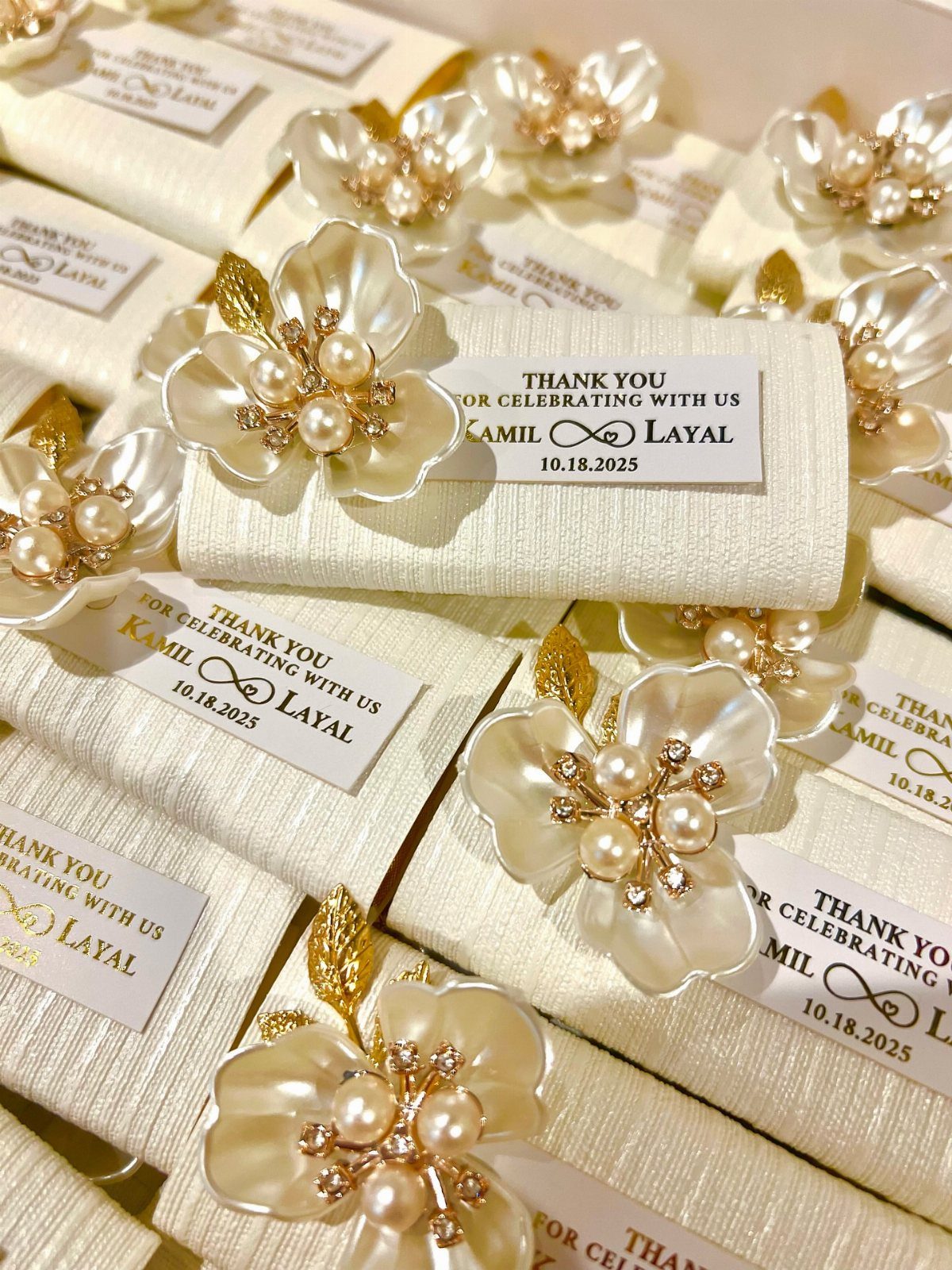 13 Cute and Fun Wedding Ideas for Guests Your Guests Will Love 13 White fabric gift boxes decorated with pearl flowers and personalized thank you labels for wedding guests.