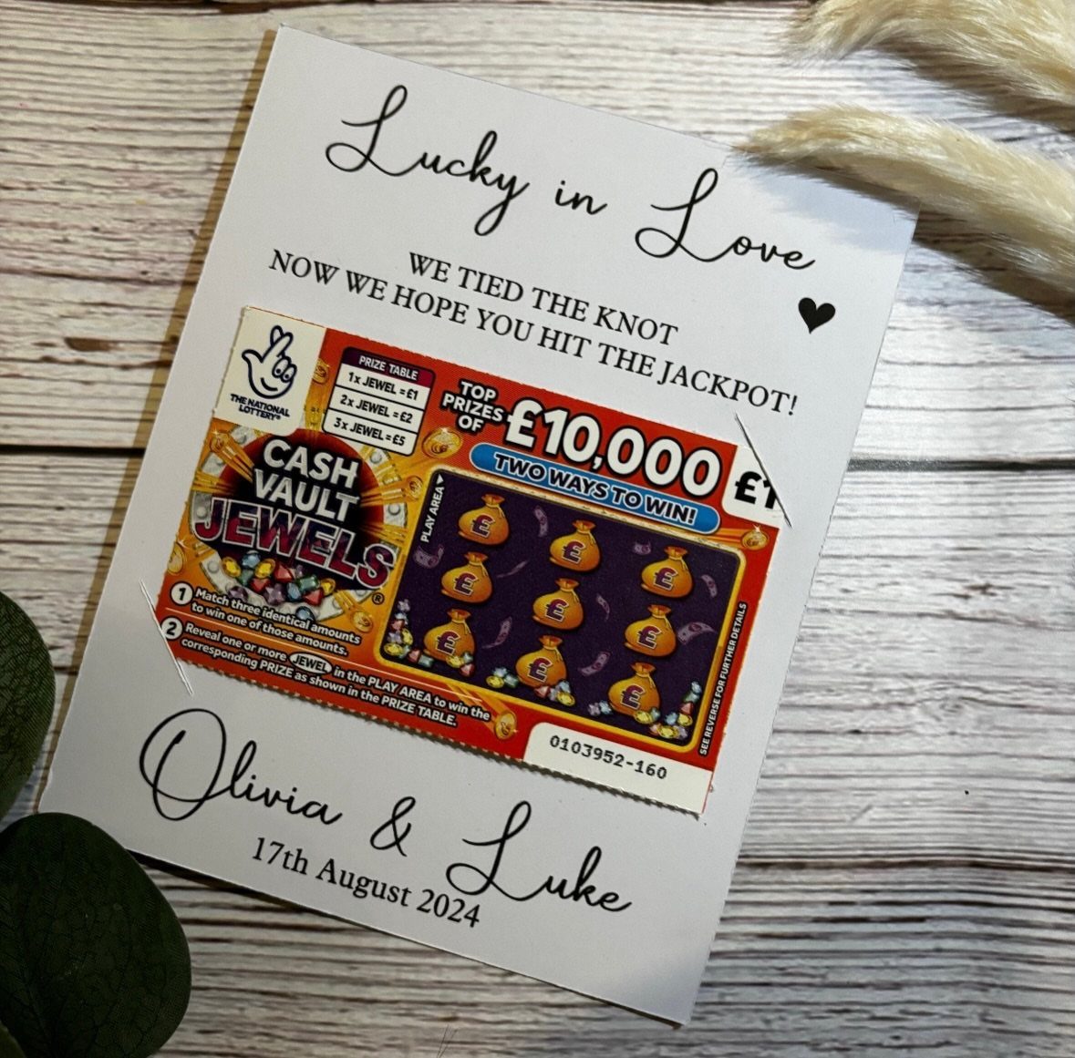 13 Cute and Fun Wedding Ideas for Guests Your Guests Will Love 7 A wedding favor card with a scratch card and names Olivia and Luke on wood.