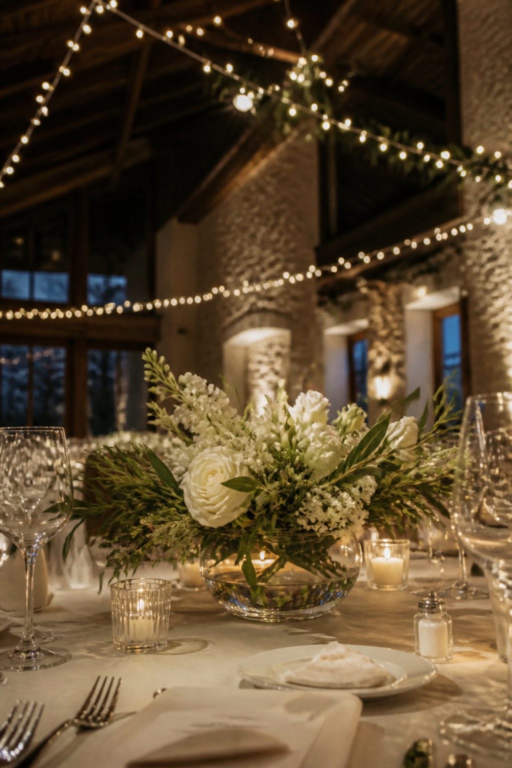 Tall floral centerpieces in trumpet vases on reception tables.