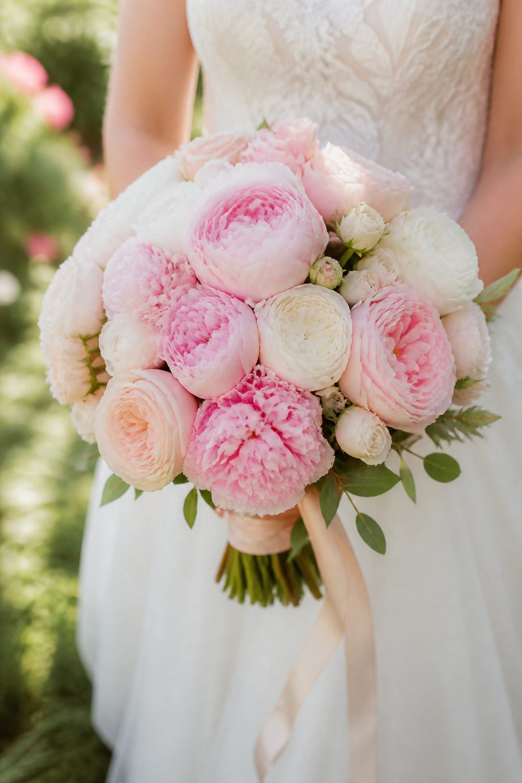 A round bouquet filled with peonies and garden roses.