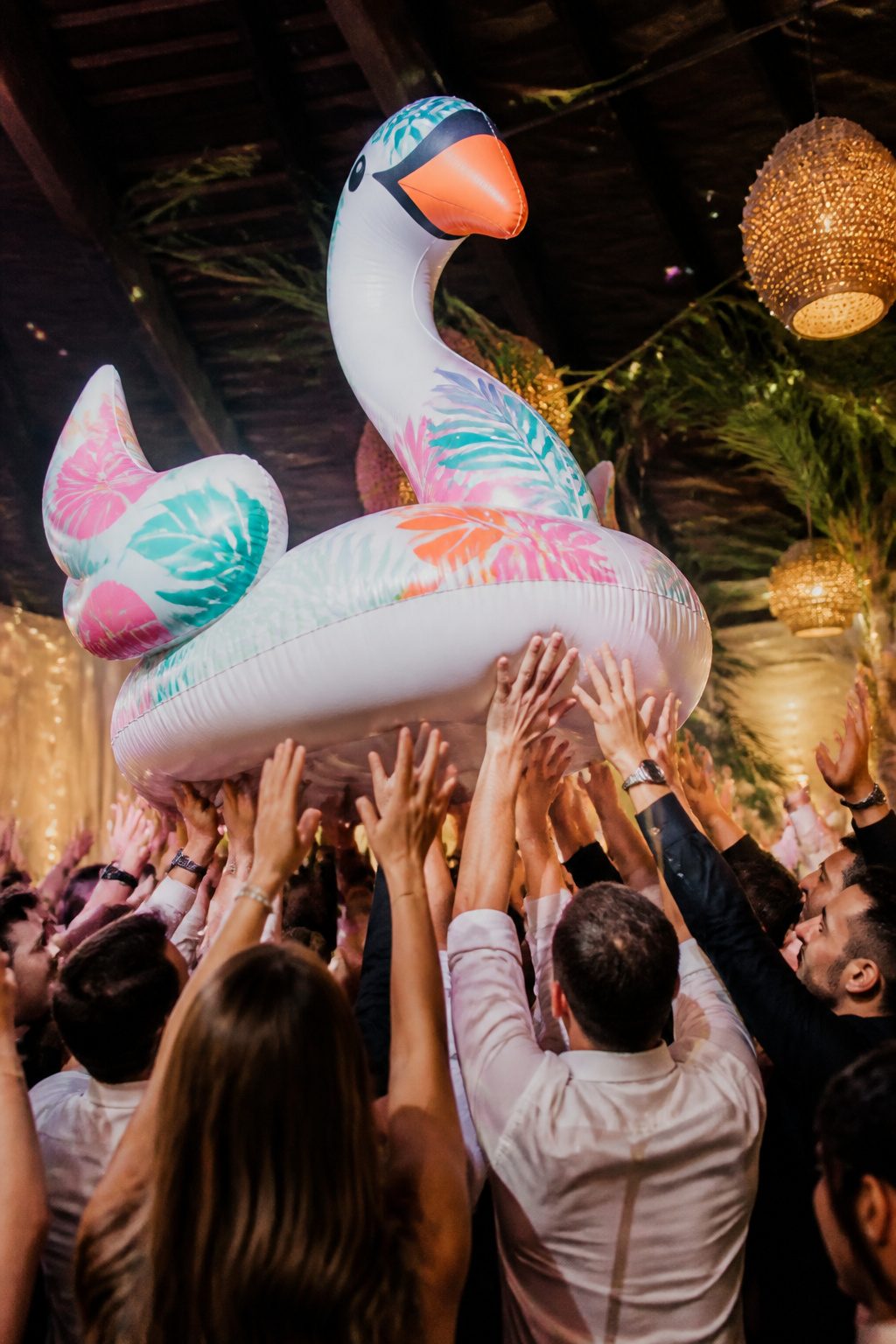 Guests crowd surfing on an inflatable float at a wedding.