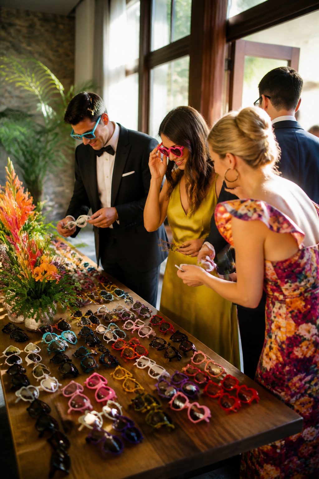A table filled with colorful party sunglasses at a wedding.