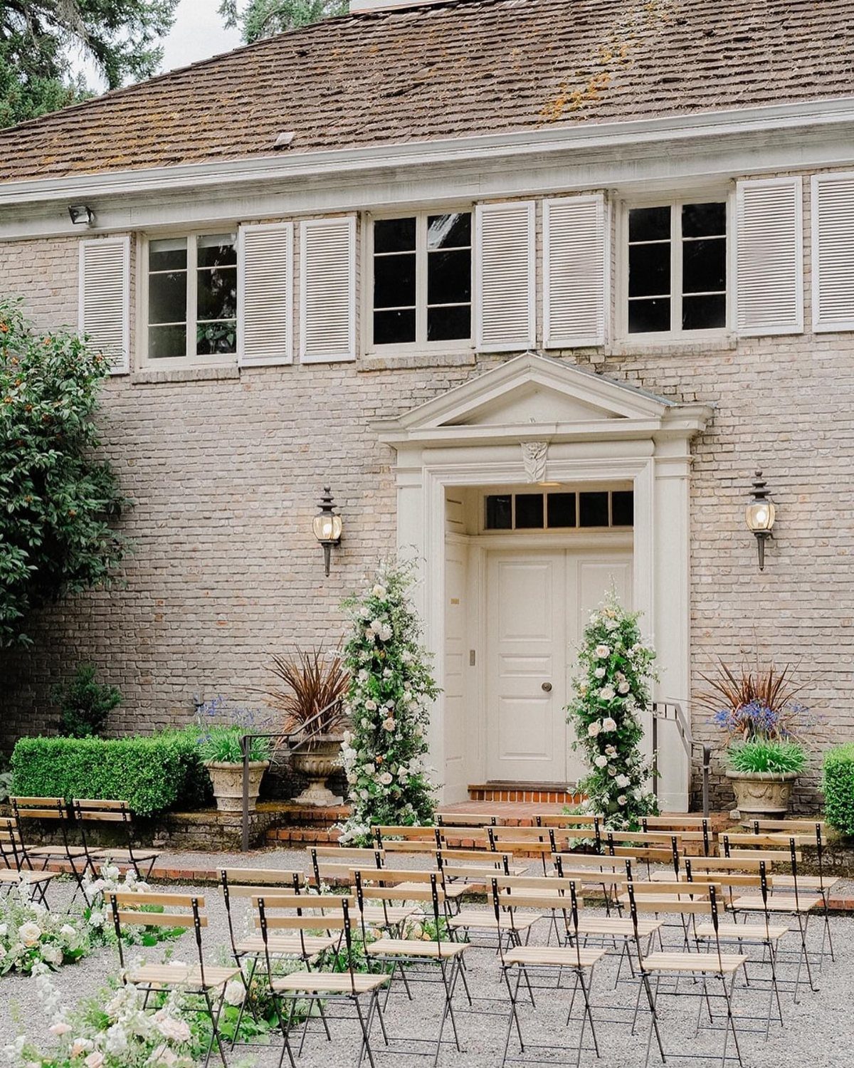 Garden Estate Wedding: 12 Ideas for Ceremony and Reception 7 Rows of wooden chairs arranged for a wedding ceremony in front of a brick estate.