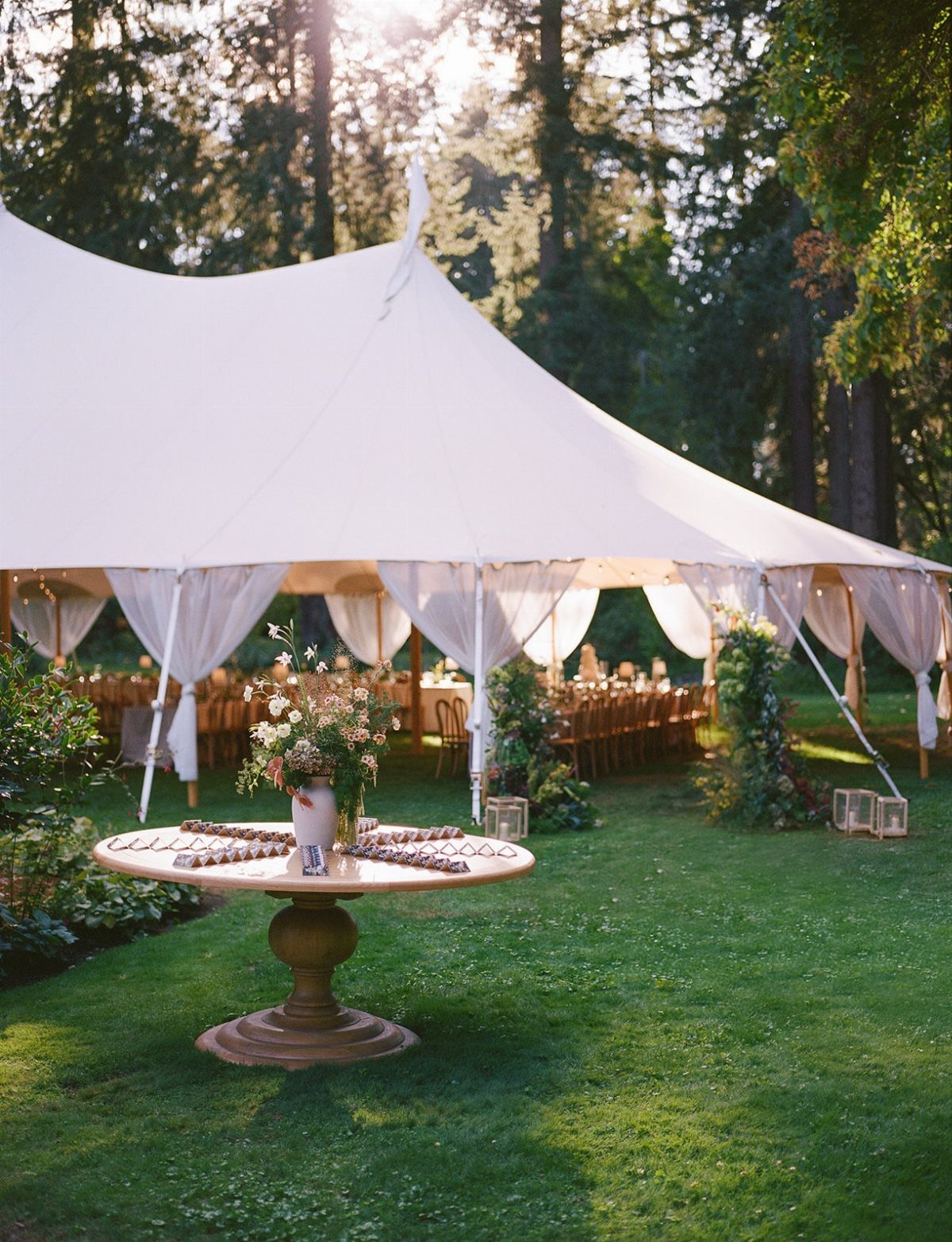 Garden Estate Wedding: 12 Ideas for Ceremony and Reception 12 A white event tent set up on a lush green lawn with an appetizer table in the foreground.