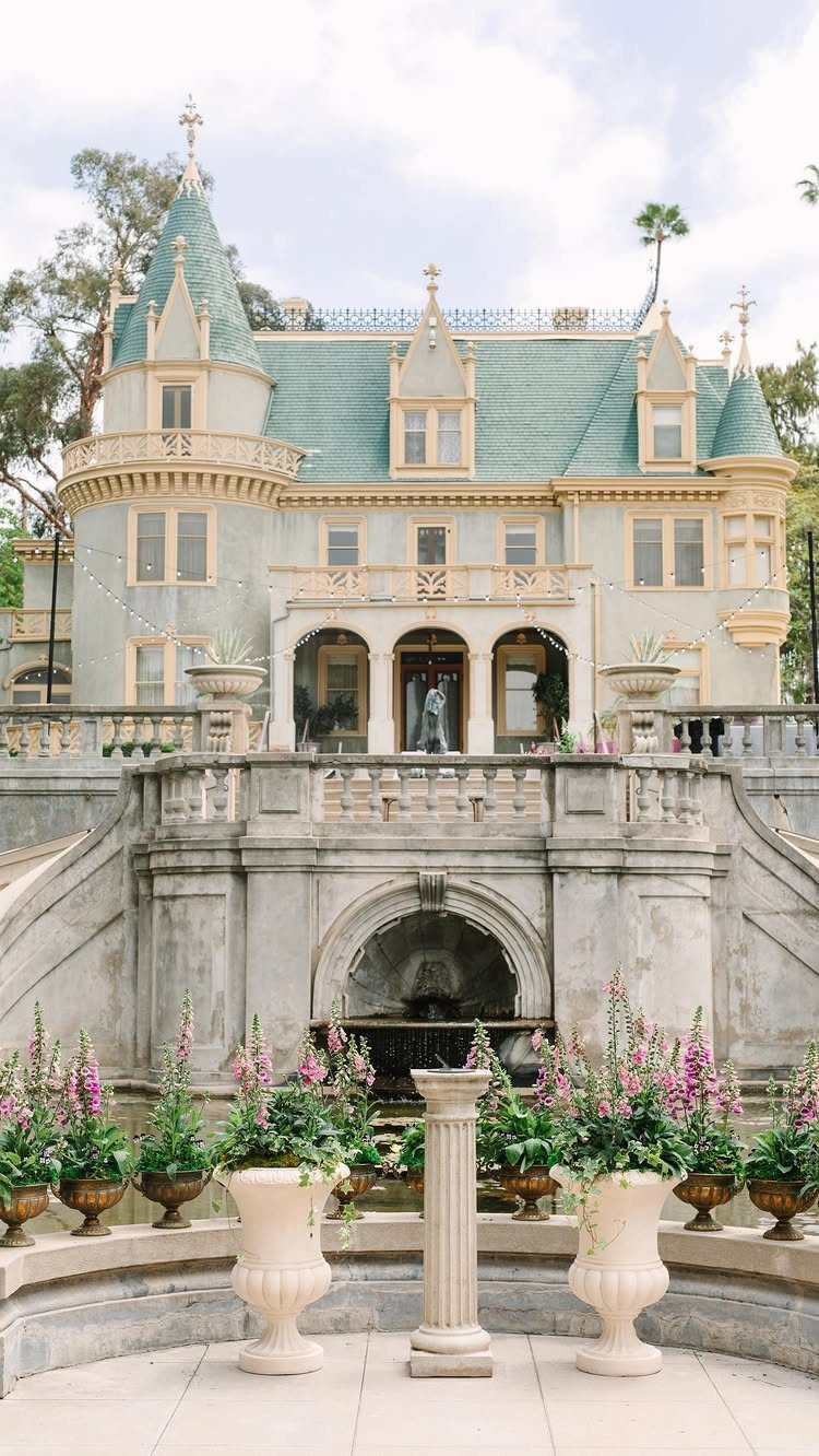 Garden Estate Wedding: 12 Ideas for Ceremony and Reception 10 A grand light blue estate with teal roofs and stone fountains surrounded by flowering urns.