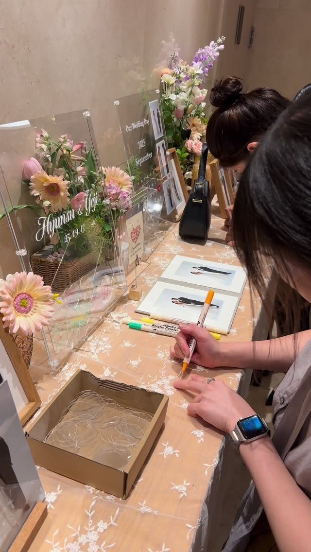 23 Indoor Wedding Decorations for Ceremony and Reception 23 A person writing in a guest book at a decorated wedding reception table.