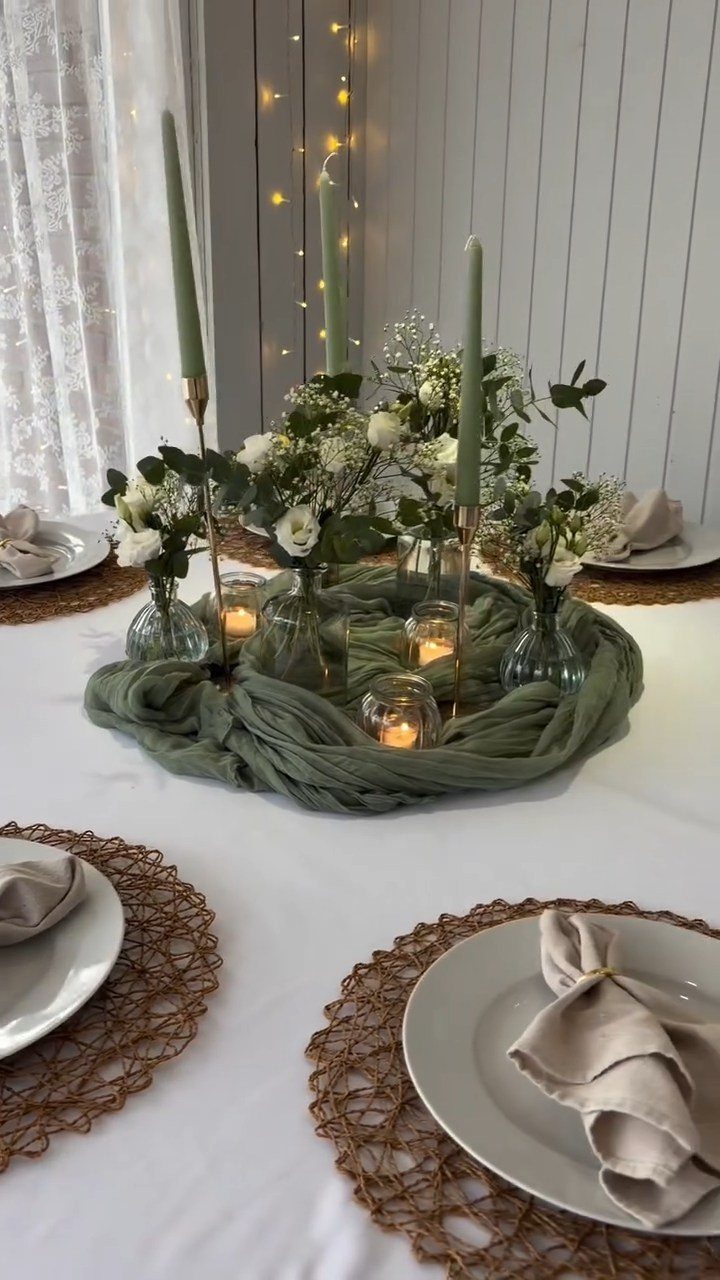 10 Lace and Greenery Wedding Table Ideas to Try 5 Green taper candles and small floral vases arranged on a sage green fabric table runner.