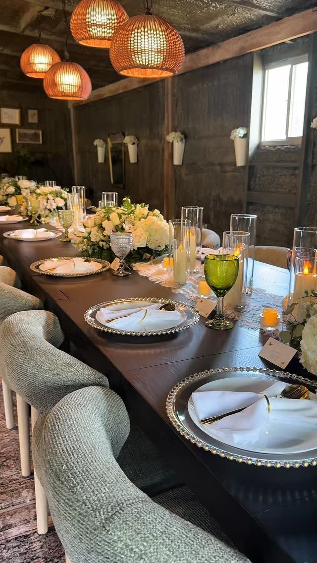 10 Lace and Greenery Wedding Table Ideas to Try 7 A long wedding table decorated with white flowers, greenery, lace, and candles under warm hanging lights.