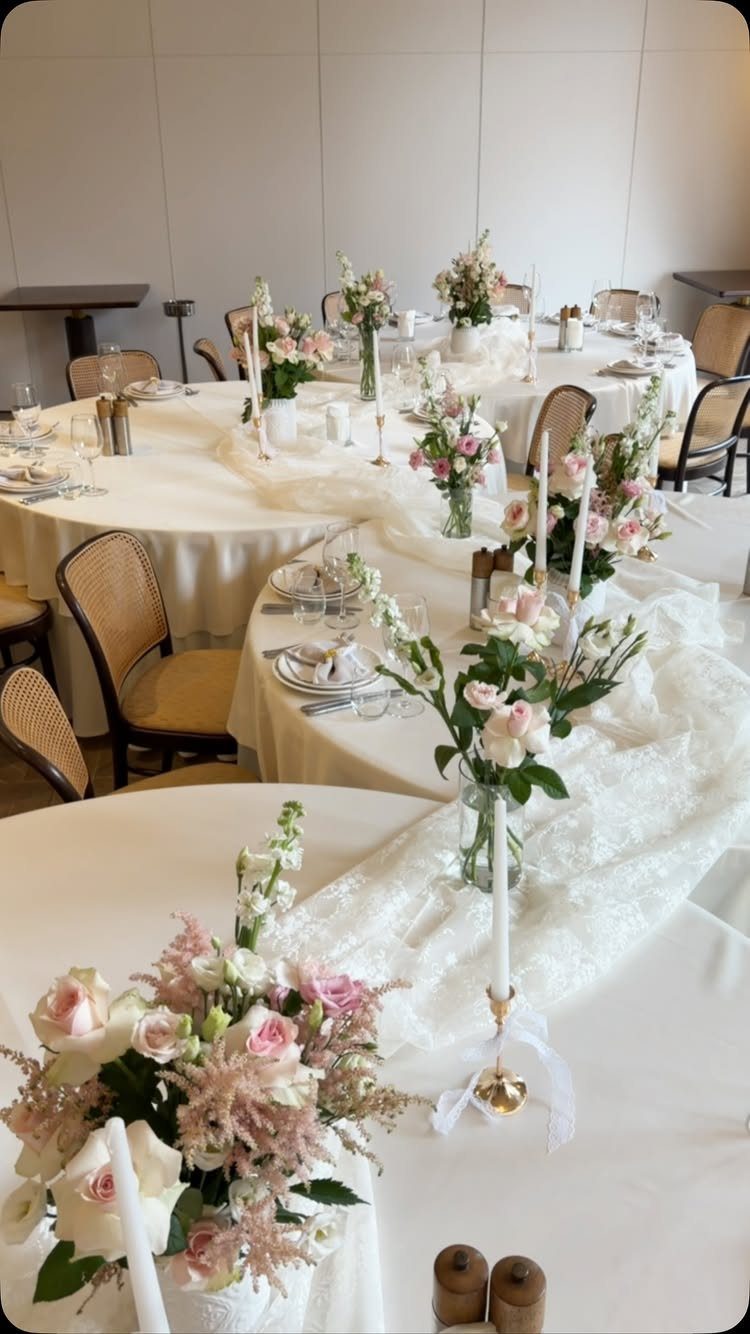 10 Lace and Greenery Wedding Table Ideas to Try 9 Wedding tables decorated with white lace runners, greenery, pink roses, and tall white taper candles.