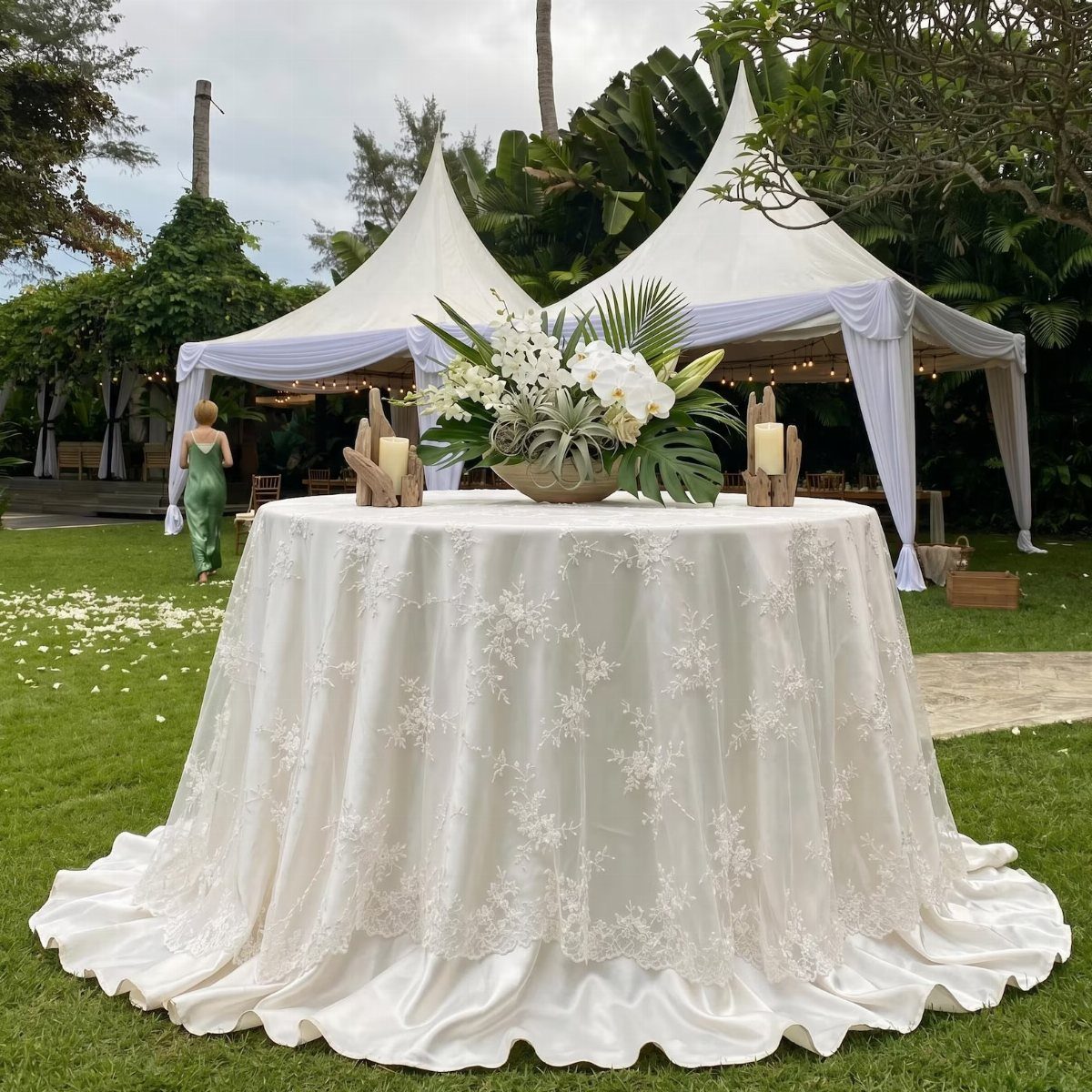 10 Lace and Greenery Wedding Table Ideas to Try 2 A round wedding table featuring a white lace tablecloth and a white orchid centerpiece.