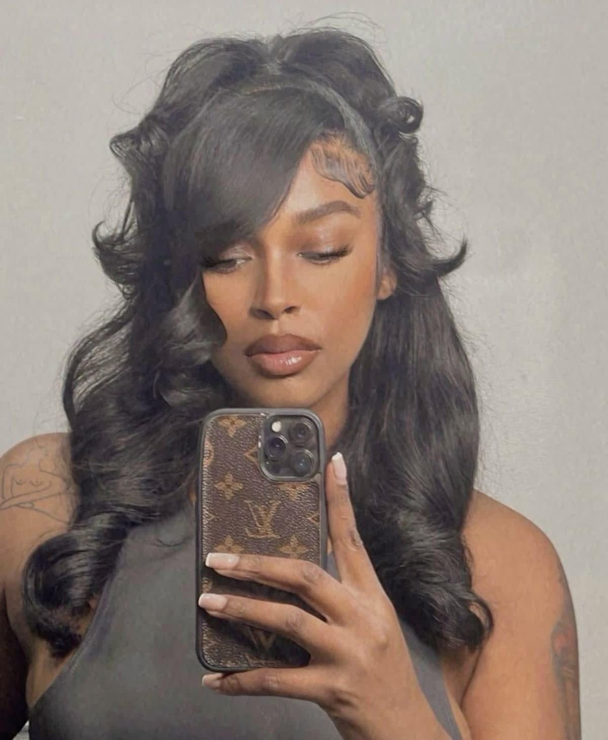 Long Hair Half Up for Wedding: 10 Styles That Work 5 Woman with long dark wavy hair in a half-updo with face-framing strands taking a selfie.