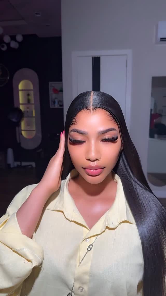 A woman with long, sleek, straight dark hair parted in the middle.