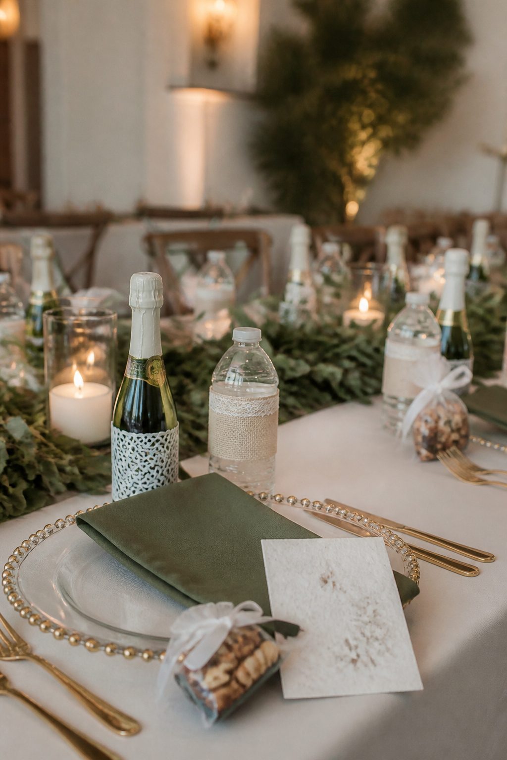 Reception table with mini champagne bottles and homemade treats.