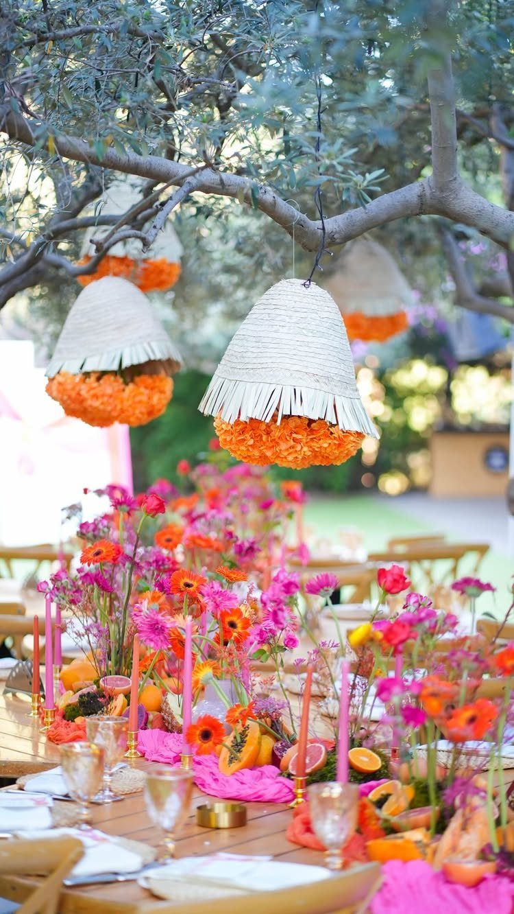 Simple Garden Wedding Reception Outdoor: 14 Stylish Ideas to Copy 3 Vibrant pink and orange floral centerpieces on a wooden table under a tree with hanging decorations.
