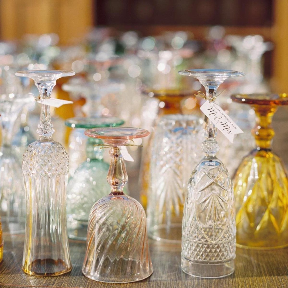 Assorted vintage crystal goblets and stemmed glassware with intricate patterns in clear and amber tones.