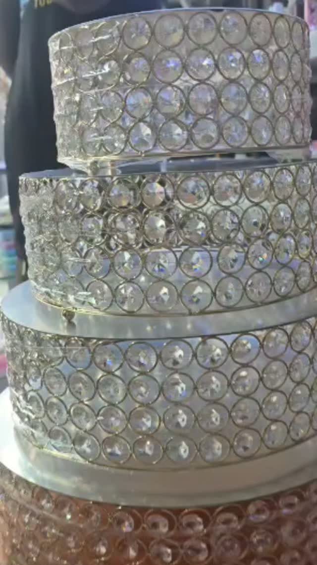 How to Choose a Wedding Cake Stand: 8 Styles for Every Reception 6 A tiered cake stand covered in sparkling, circular clear rhinestones in a silver setting.