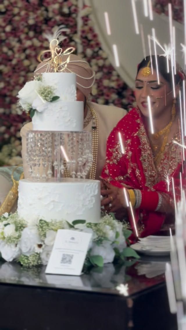 How to Choose a Wedding Cake Stand: 8 Styles for Every Reception 1 A white tiered wedding cake with floral decorations and a gold topper on a table.