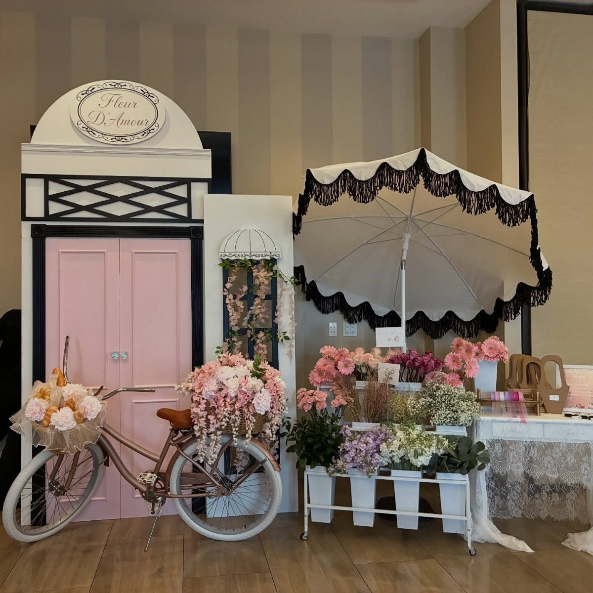 20 Wedding Decor DIY Ideas for Ceremony and Reception 14 A pink vintage bicycle decorated with abundant pink flowers parked in front of a storefront.