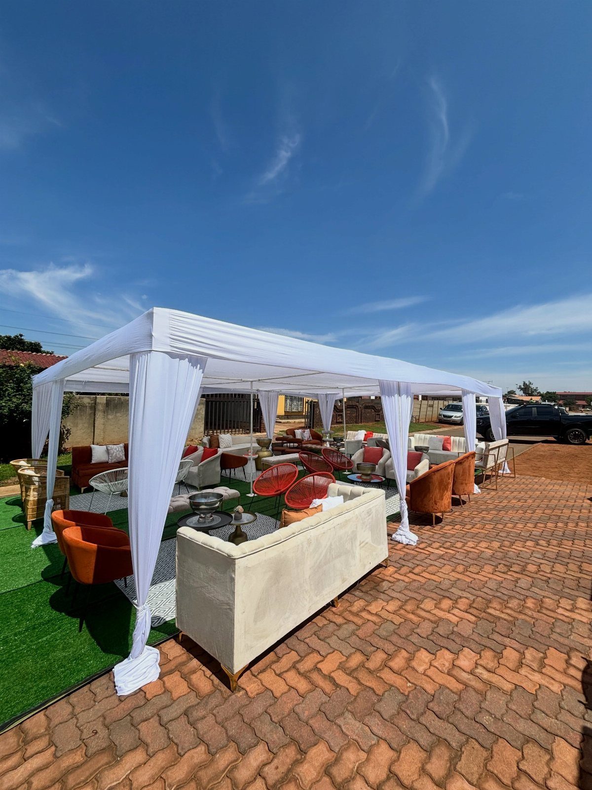 22 Wedding Decor Garden Theme Ideas for Every Reception Style 20 White canopy tent containing various plush sofas and armchairs arranged on artificial grass.