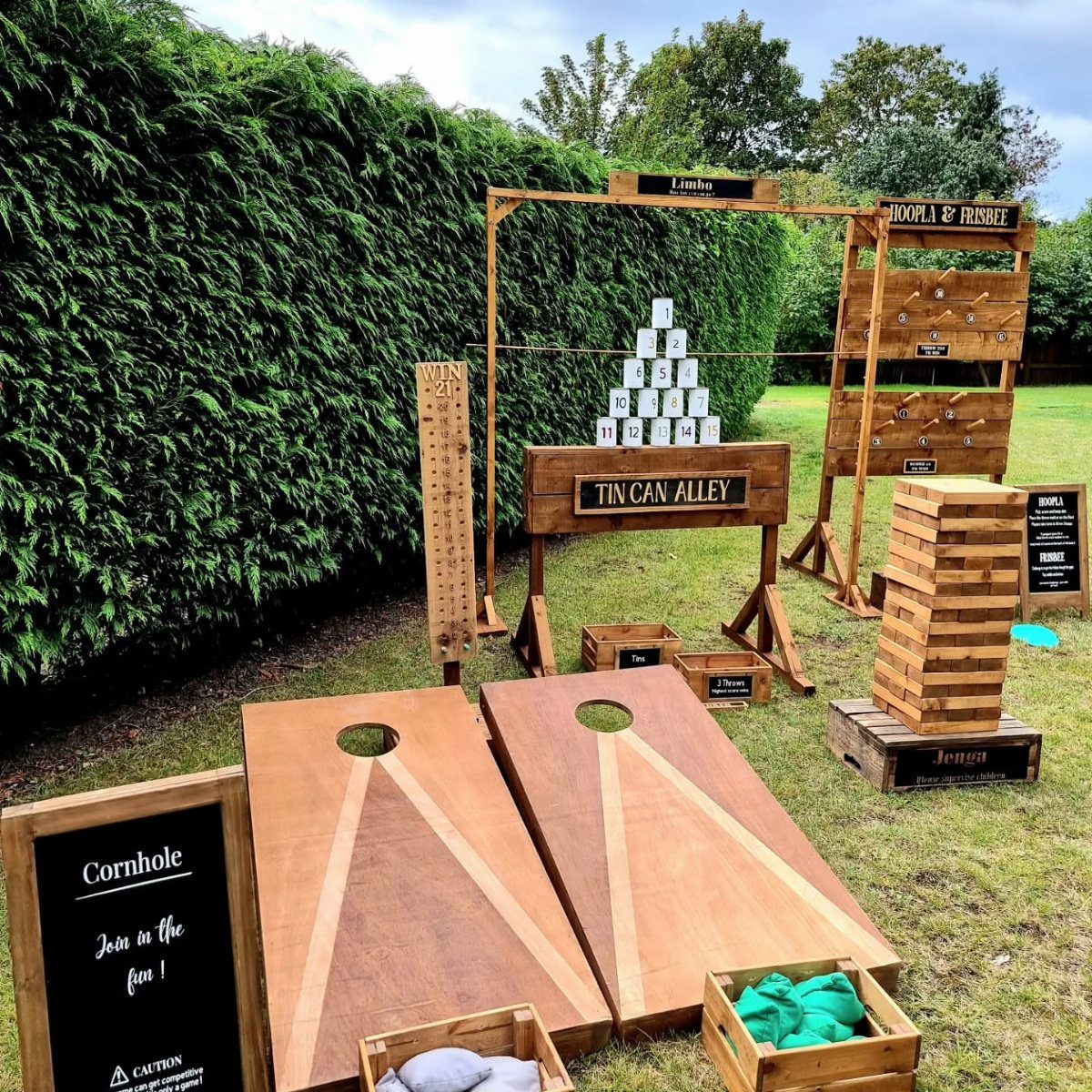 22 Wedding Decor Garden Theme Ideas for Every Reception Style 10 Wooden cornhole boards and various outdoor lawn games set on a green grass lawn.