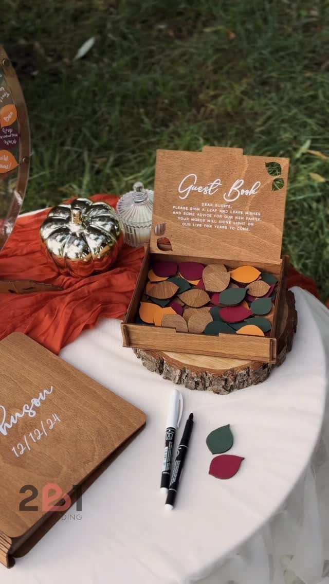 22 Wedding Decor Garden Theme Ideas for Every Reception Style 22 Wooden guest book box filled with colorful leaves next to a wooden plaque and markers.