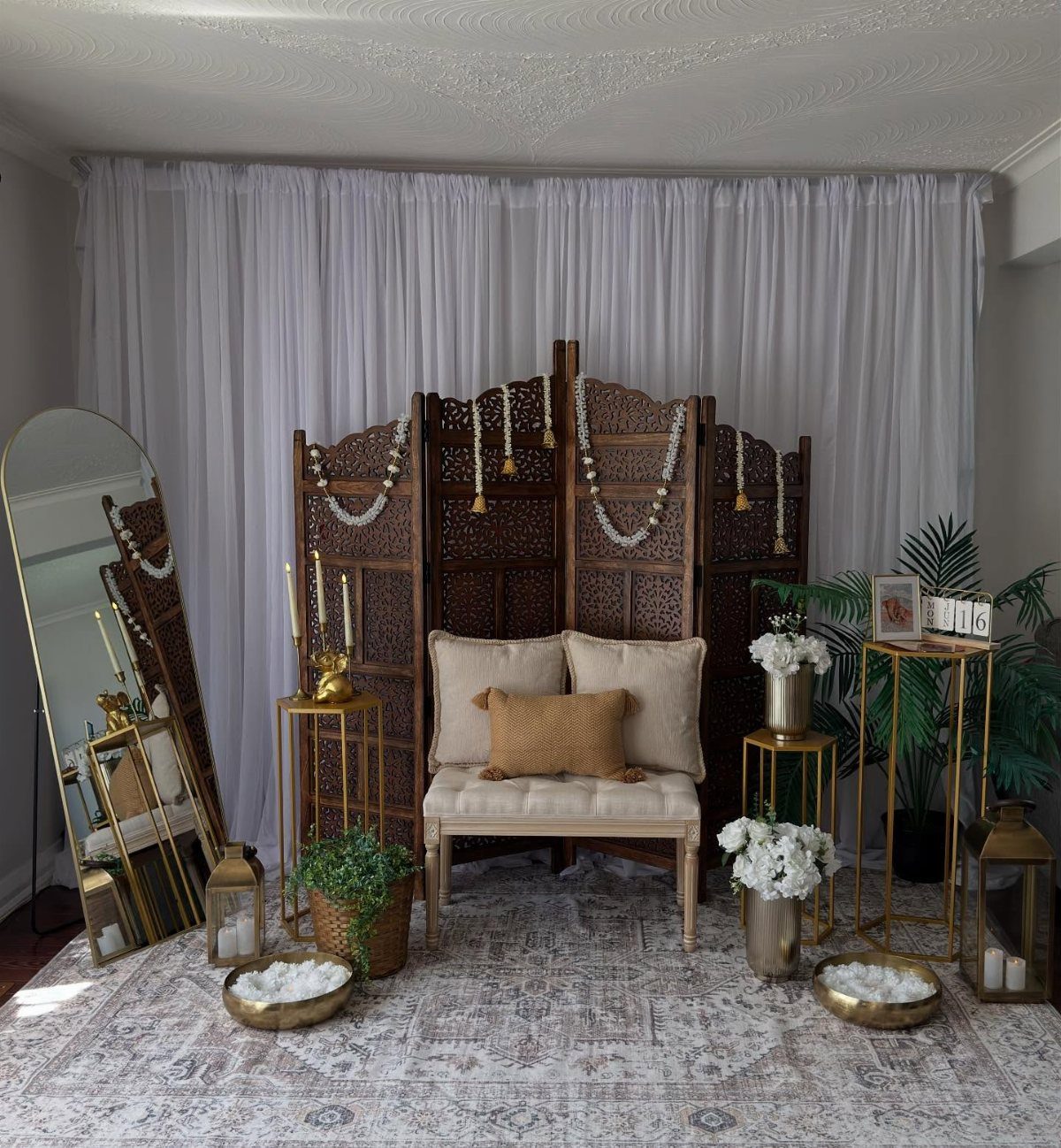 11 Wedding Decor Room Ideas for Your Reception in 2026 10 A decorated room with a wooden screen, cream bench, gold accents, and white floral arrangements.