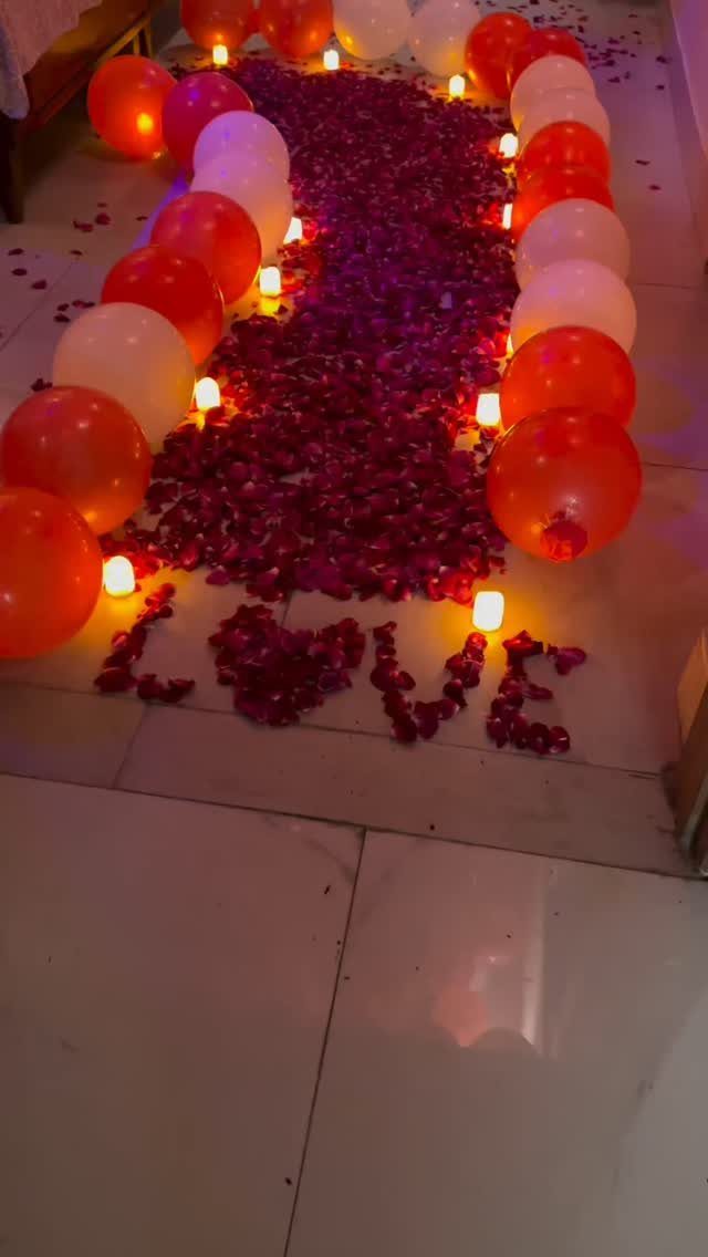 11 Wedding Decor Room Ideas for Your Reception in 2026 5 Red and white balloons lining a path of rose petals on a floor with candles.