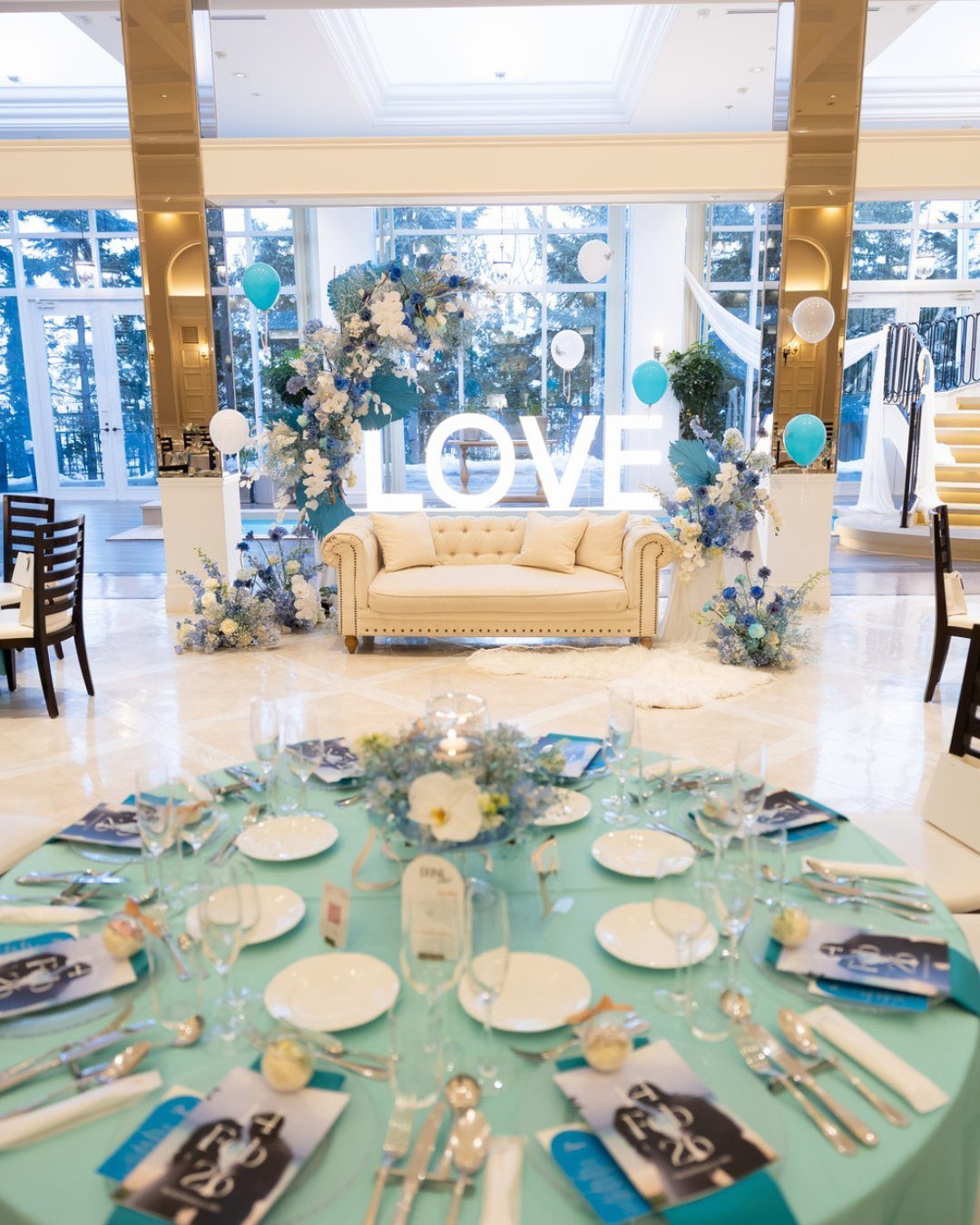 Wedding Decor and Themes: 12 Ideas From Beach to Garden 10 A decorated wedding reception table with light blue linens and floral centerpieces in a bright room.