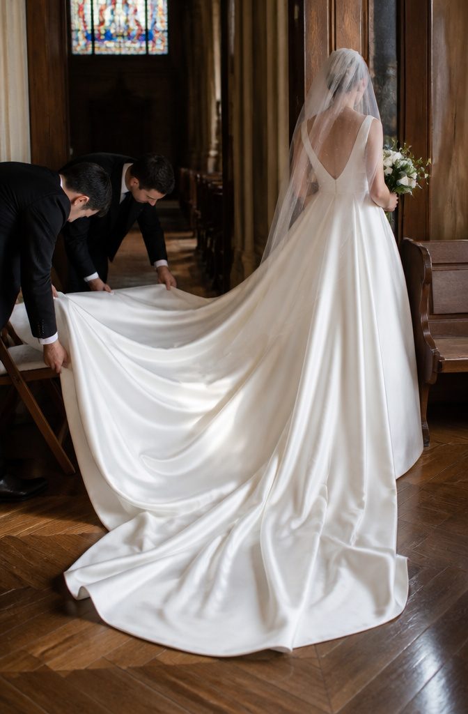 Wedding Dress Long Train: A Guide to Train Styles and Lengths 1 Bride walking with a long cathedral train in a softly lit church.