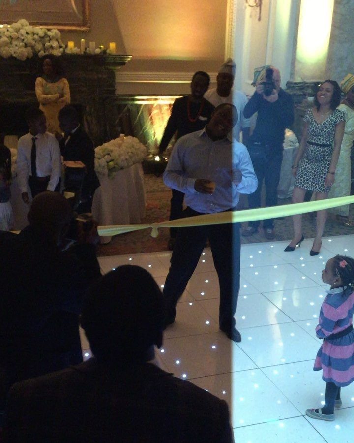 A man dancing under a yellow limbo bar on a glowing white dance floor.