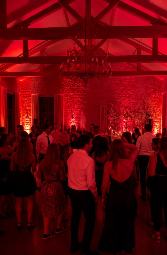 20 Wedding Reception Ideas for a 2026 Party Guests Won't Forget 15 A wedding reception dance floor illuminated with red lights.