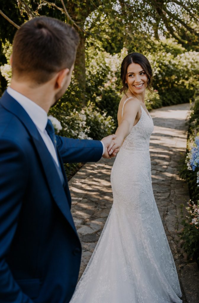 15 Wedding Photo Ideas for Bride and Groom | Poses Guide 2026 7 Bride walking ahead while groom reaches for her hand.