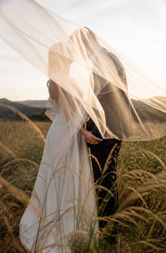 15 Wedding Photo Ideas for Bride and Groom | Poses Guide 2026 12 Bride and groom behind a veil in a meadow.