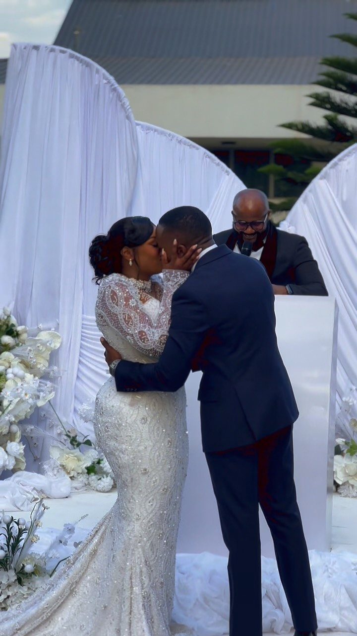 9 Wedding Photos Poses for Every Part of Your Day 3 A bride and groom kissing during their wedding ceremony outdoors.