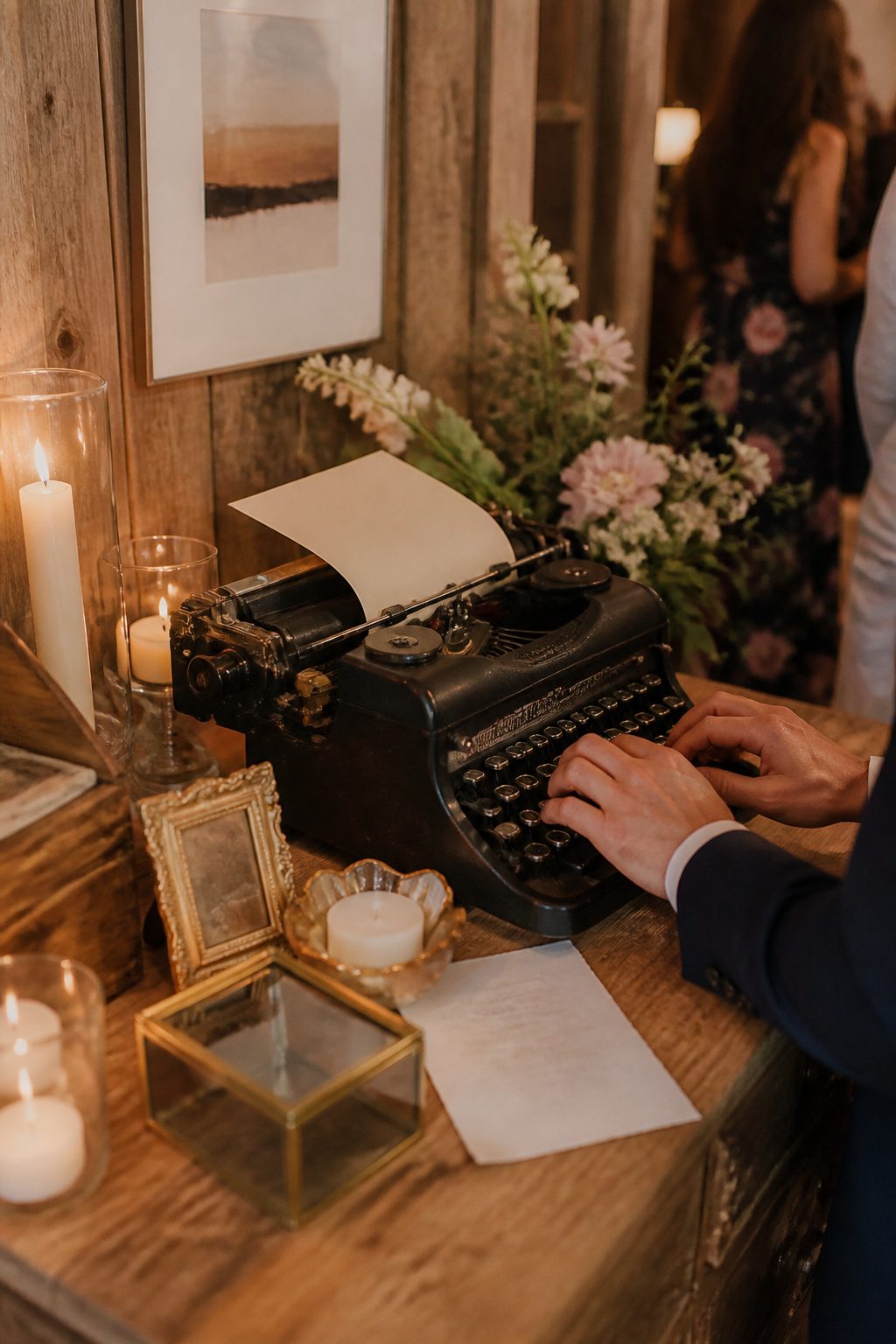 20 Wedding Sign In Ideas Guest Books Couples Actually Keep 10 A vintage typewriter on a wooden table surrounded by flowers.