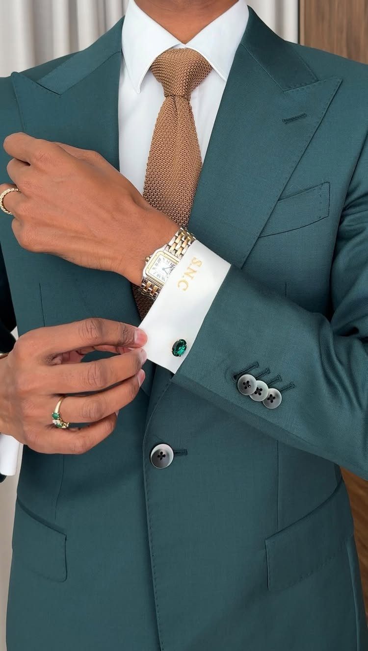 10 Wedding Theme Teal Ideas for Color, Decor and Attire 10 Man in a teal suit adjusting his white shirt cuffs and gold tie.