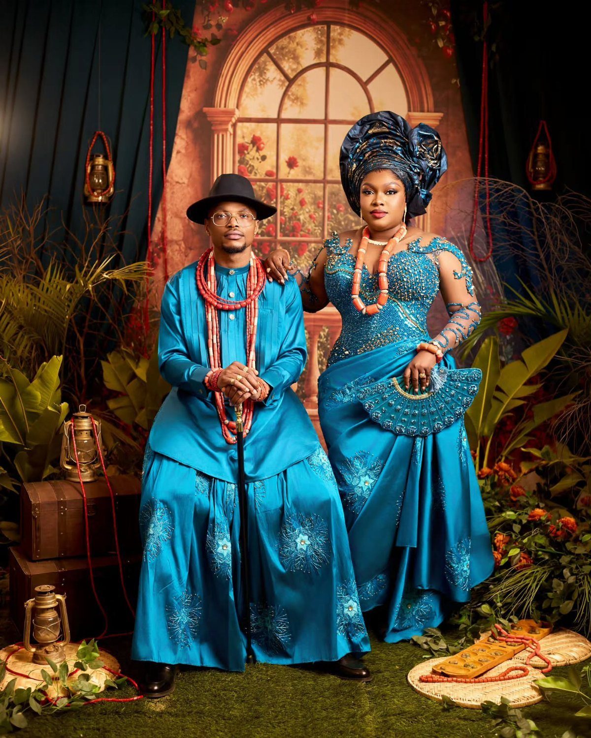 10 Wedding Theme Teal Ideas for Color, Decor and Attire 6 A man and woman posing in matching teal traditional African clothing and red coral bead necklaces.